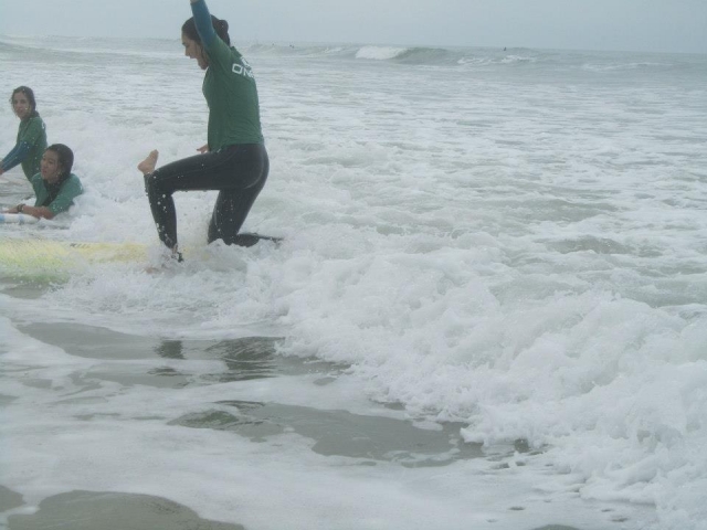 mujer levantandose en tabla de surf